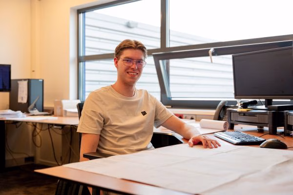 Jongen zittend achter bureau