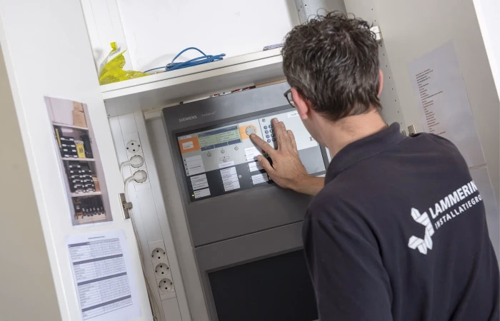 Werknemer Lammerink Installatiegroep kijkt in meterkast