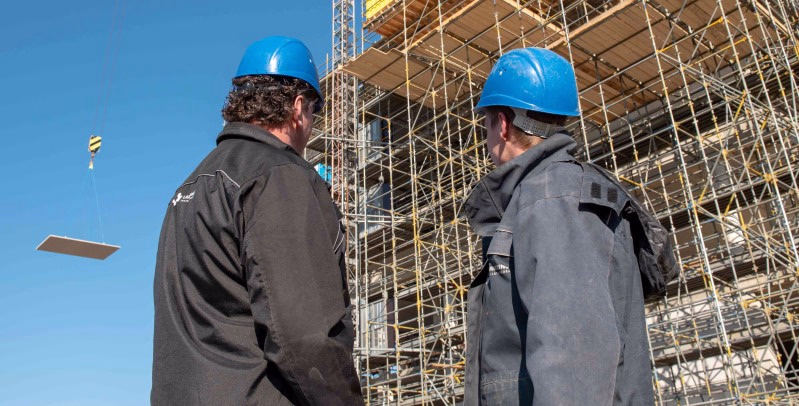 2 mannen kijkend naar de bouw